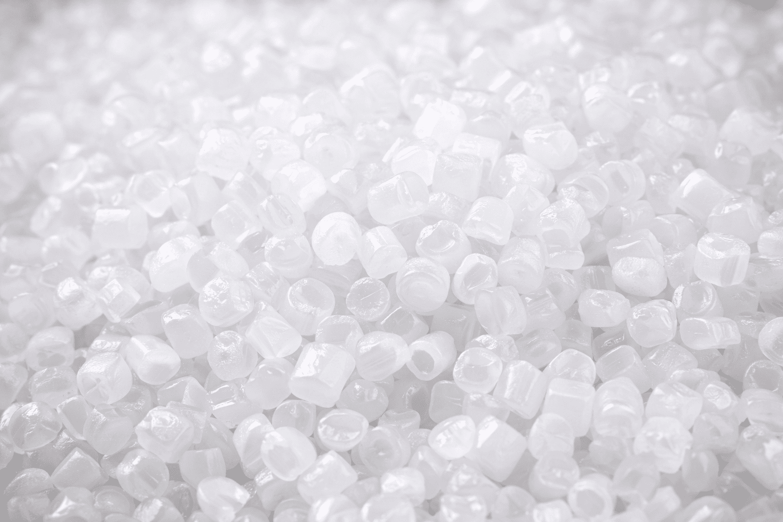 Close-up of white HDPE HBM 5510 resin pellets, showing uniform cylindrical shape, texture, and high-quality material for industrial blow molding applications.